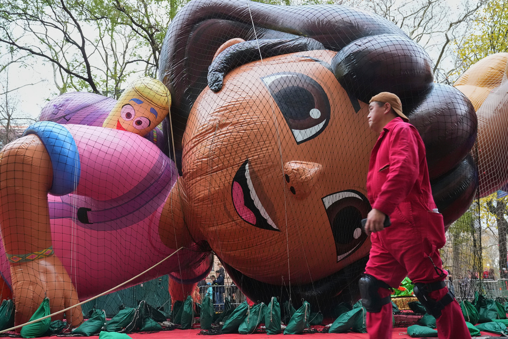 A volunteer passes the Nickelodeon's Dora balloon during the balloon inflation for the 99th Macy's Thanksgiving Day Parade Wednesday, Nov. 26, 2025, in New York. (AP Photo/Frank Franklin II)