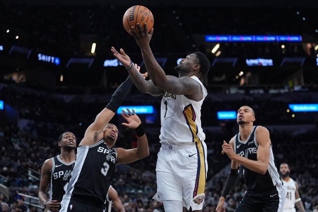 New Orleans Pelicans forward Zion Williamson (1) drives to the basket over San Antonio Spurs forward Keldon Johnson (3) during the first half of an NBA basketball game in San Antonio, Sunday, Jan. 25, 2026. (AP Photo/Eric Gay)