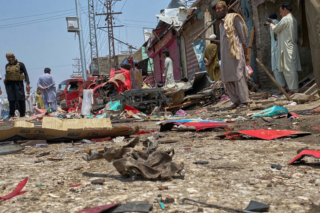 A police officer, left, and local residents examine damage at the site of a bomb explosion at a market in Sarai Norag in Lakki Marwat, a district in Pakistan's Khyber Pakhtunkhwa province, Tuesday, May 12, 2026. (AP Photo/Farhat Ullah)