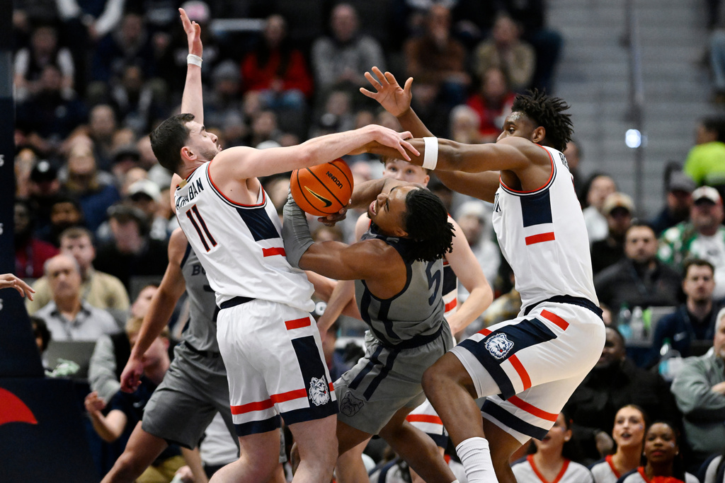 UConn forward Alex Karaban, left, and UConn forward Tarris Reed Jr., right, block a shot attempt by Butler forward Michael Ajayi, center, in the first half of an NCAA college basketball game, Tuesday, Dec. 16, 2025, in Hartford, Conn. (AP Photo/Jessica Hill)