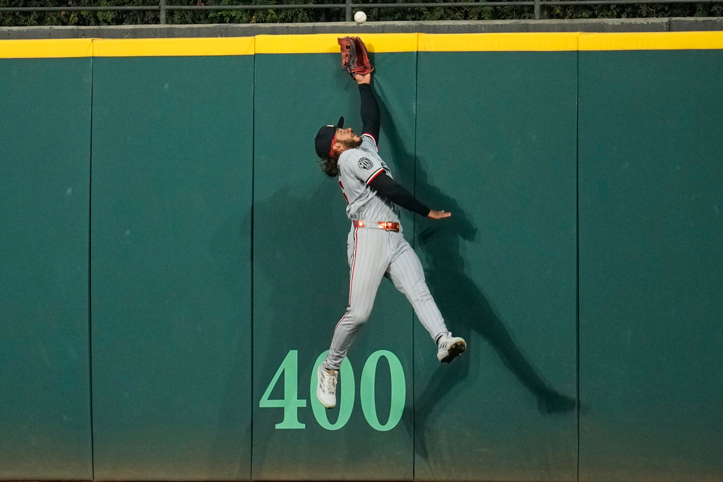Minnesota Twins center fielder Austin Martin jumps for but can't get to a ball hit for a home run by Cleveland Guardians' Patrick Bailey in the seventh inning of a baseball game in Cleveland, Monday, July 20, 2026. (AP Photo/Sue Ogrocki)