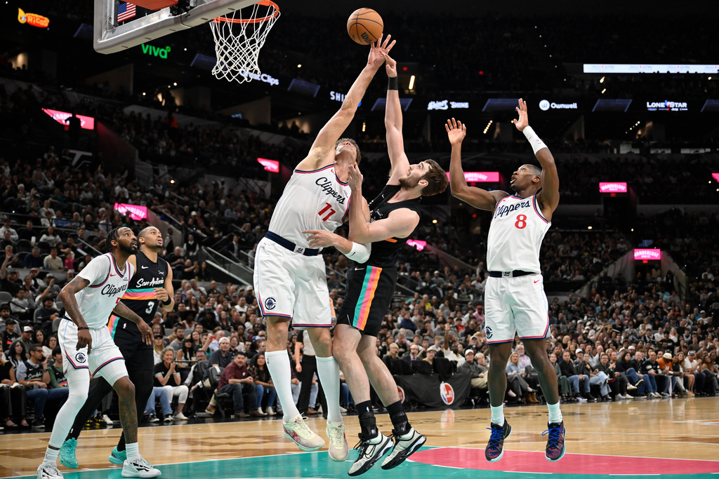 San Antonio Spurs center Luke Kornet and Los Angeles Clippers center Brook Lopez (11) fight for possession during the first half of an NBA basketball game, Friday, March 6, 2026, in San Antonio. (AP Photo/Darren Abate)