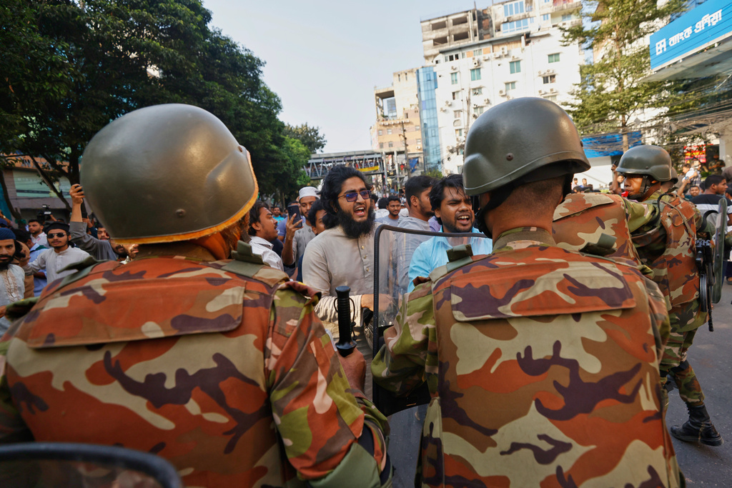 Police use baton to disperse protesters gather outside the demolished residence of Sheikh Mujibur Rahman, Bangladesh's former leader and the father of the country's ousted Prime Minister Sheikh Hasina after the verdict against Hasina, in Dhaka, Bangladesh, Monday, Nov. 17, 2025. (AP Photo/ Rajib Dhar)