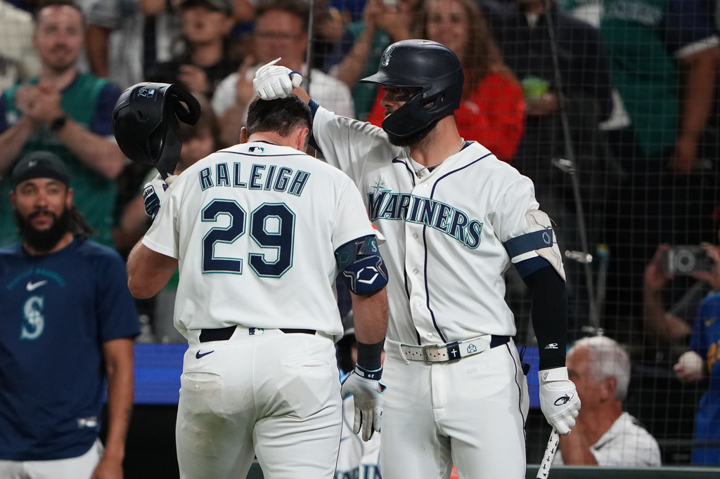 Seattle Mariners' Cal Raleigh (29) is greeted by teammate Weston Wilson after hitting a solo home run against the Philadelphia Phillies during the fifth inning of a baseball game, Monday, Aug. 24, 2026, in Seattle. (AP Photo/Lindsey Wasson)