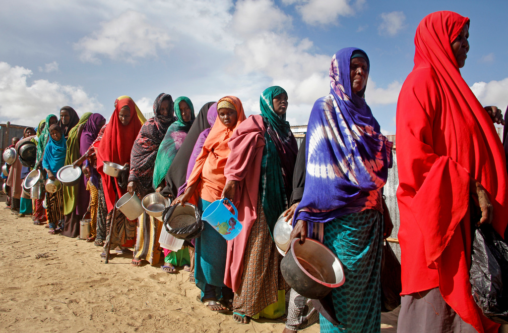 FILE - In this May 18, 2019 file photo, newly-arrived women who fled drought line up to receive food distributed by local volunteers at a camp for displaced persons in the Daynile neighborhood on the outskirts of the Somalian capital Mogadishu. (AP Photo/Farah Abdi Warsameh, file)