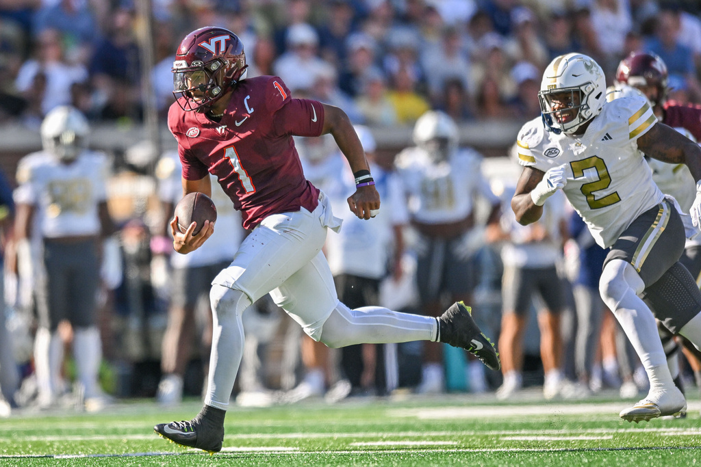 Georgia Tech linebacker E.J.L.ightsey (2) is unable to stop Virginia Tech quarterback Kyron Drones (1) from scoring a touchdown during the first half of an NCAA college football game, Saturday, Oct. 11, 2025 at Bobby Dodd Stadium in Atlanta. (Daniel Varnado/Atlanta Journal-Constitution via AP)