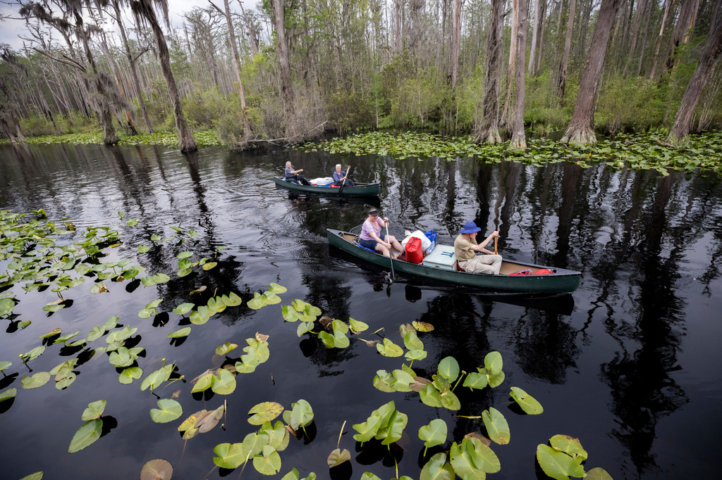FILE - Visitors return to Stephen C. Foster State Park after an overnight camping trip on the Red Trail in the Okefenokee National Wildlife Refuge in Fargo, Ga., April 6, 2022. (AP Photo/Stephen B. Morton, File)