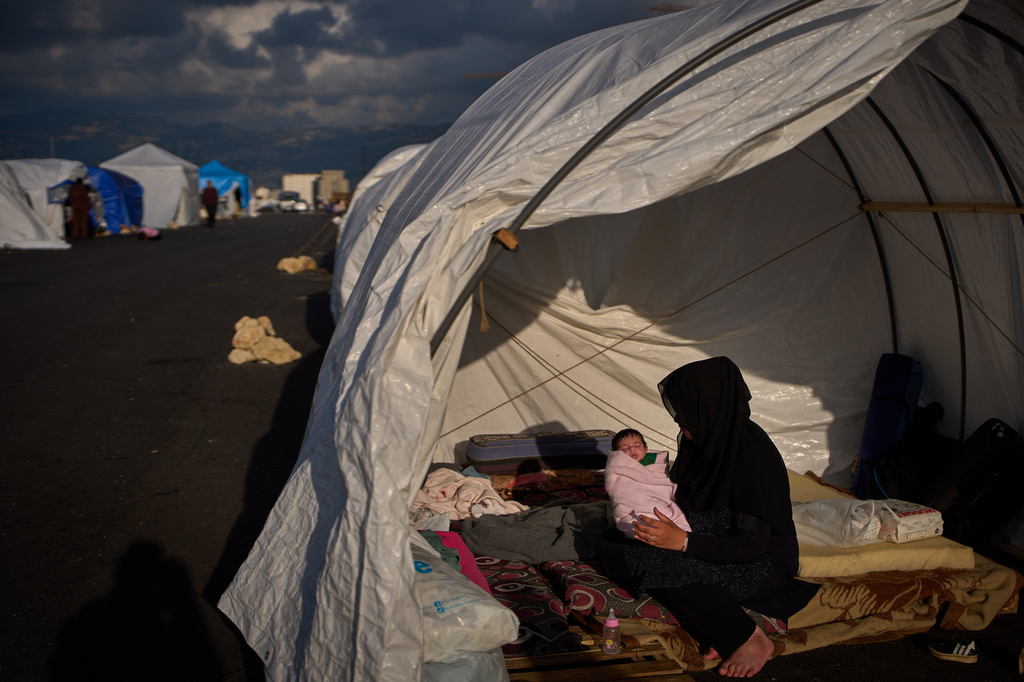 Haifa Kenjo, who fled Israeli airstrikes on the southern suburbs of Beirut, holds her 15-day-old daughter Shiman inside the tent she uses as a shelter and where she gave birth to her in Beirut, Sunday, April 12, 2026. (AP Photo/Emilio Morenatti)