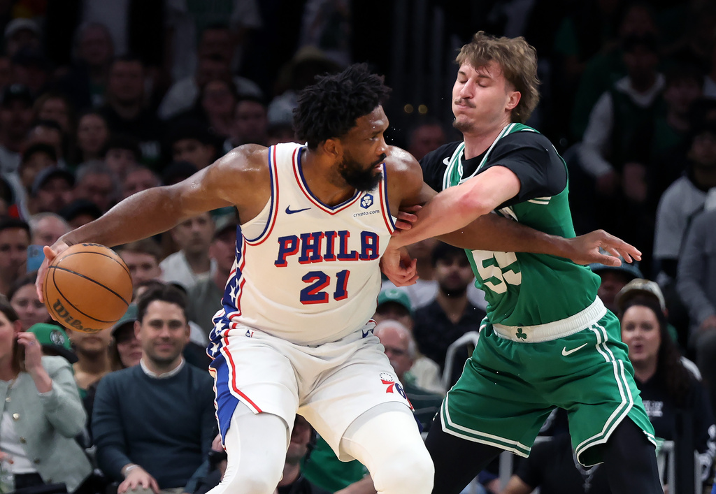 Boston Celtics' Jayson Baylor Scheierman (right) defends agianst Philadelphia 76ers' Joel Embiid (left) during the first half of Game 7 in a first-round NBA basketball playoffs series, Saturday, May 2, 2026 in Boston. (AP Photo/Jim Davis)