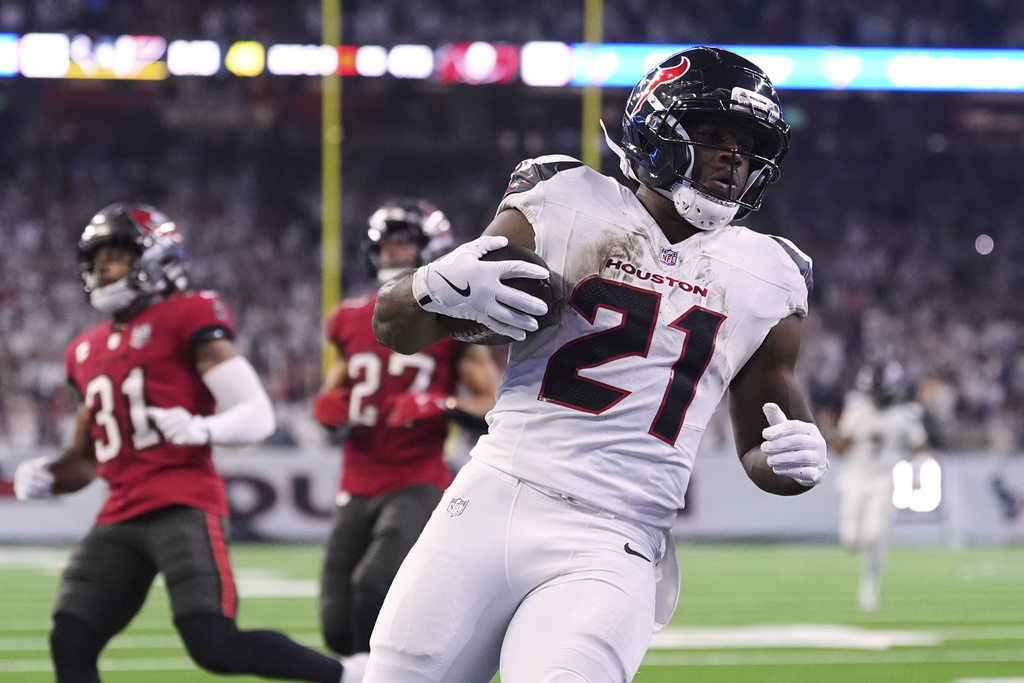 Houston Texans running back Nick Chubb (21) runs the ball for a touchdown as Tampa Bay Buccaneers' Antoine Winfield Jr. (31) and Zyon McCollum (27) give chase in the second half of an NFL football game Monday, Sept. 15, 2025, in Houston, Texas. (AP Photo/Eric Gay)
