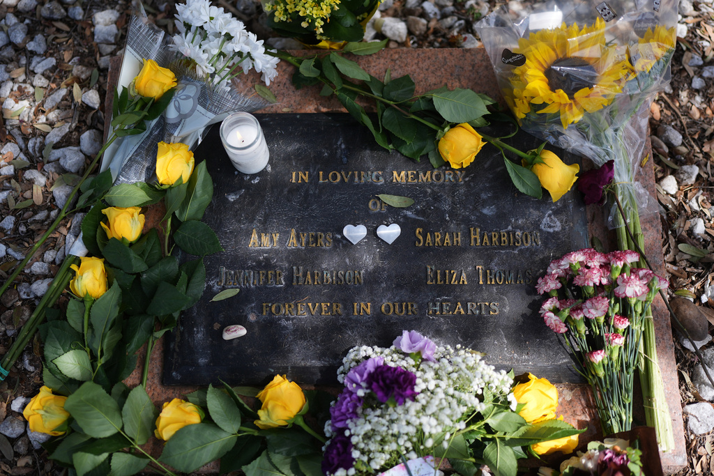 Following a news conference where a breakthrough in the 1991 I Can't Believe It's Yogurt murder case, fresh flowers and new notes rest on a plaque placed for the victims, Monday, Sept. 29, 2025, in Austin, Texas. (AP Photo/Eric Gay)