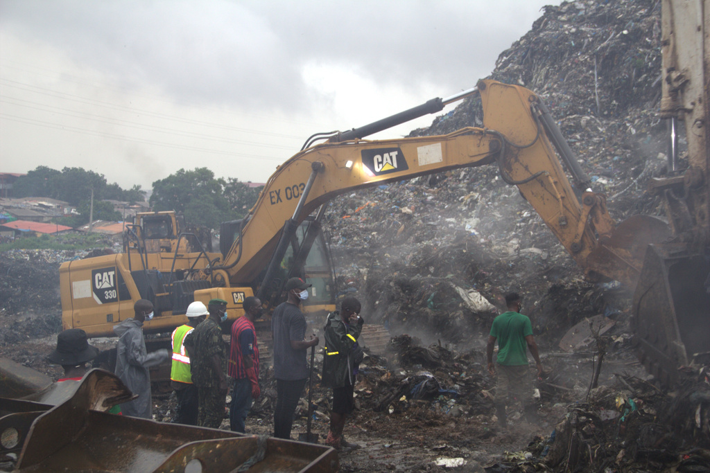 Rescue workers search through a heap of refuse after it collapsed at Conakry’s largest landfill, Guinea, Sunday, Aug. 23, 2026. (AP Photo/Fodo Toure)