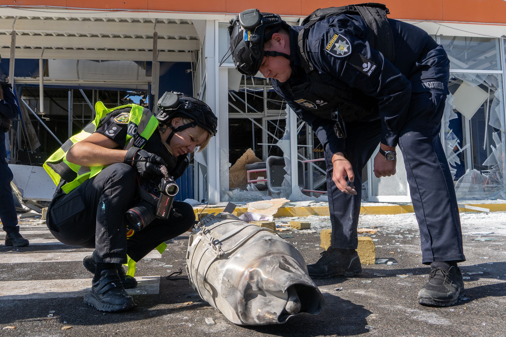 Police officers inspect fragments of a Russian drone after an air attack on a commercial infrastructure in Kharkiv, Ukraine, Thursday, Sept. 17, 2026. (AP Photo/Andrii Marienko)