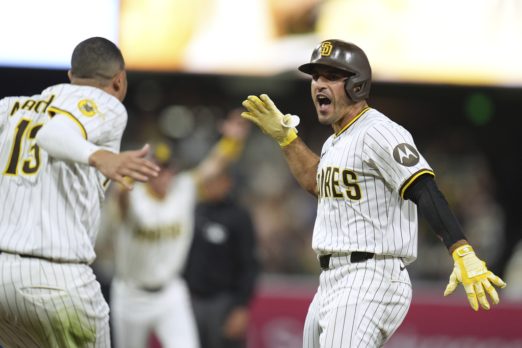 San Diego Padres' Ramon Laureano, right, celebrates with teammate third baseman Manny Machado after hitting a walk-off RBI single during the tenth inning of a baseball game Saturday, Aug. 9, 2025, in San Diego. The Padres won 5-4. (AP Photo/Gregory Bull)
