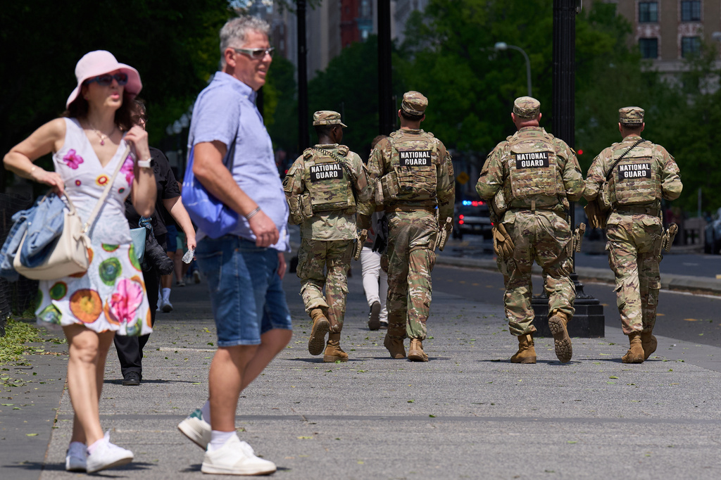 FILE - Members of the Florida National Guard pass by people on a sidewalk, April 17, 2026, in Washington. (AP Photo/Jacquelyn Martin, File)