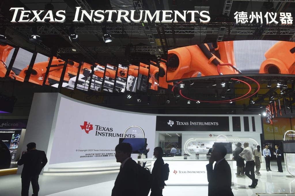 Visitors pass by the booth for Texas Instruments during the China International Imports Expo in Shanghai, China on Nov. 6, 2023. (Chinatopix via AP)