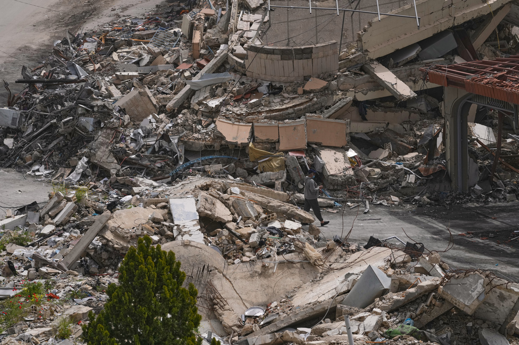 A man walks between destroyed buildings on the second day of a ceasefire between Hezbollah and Israel in Nabatiyeh town, south Lebanon, Saturday, April 18, 2026.(AP Photo/Mohammed Zaatari)