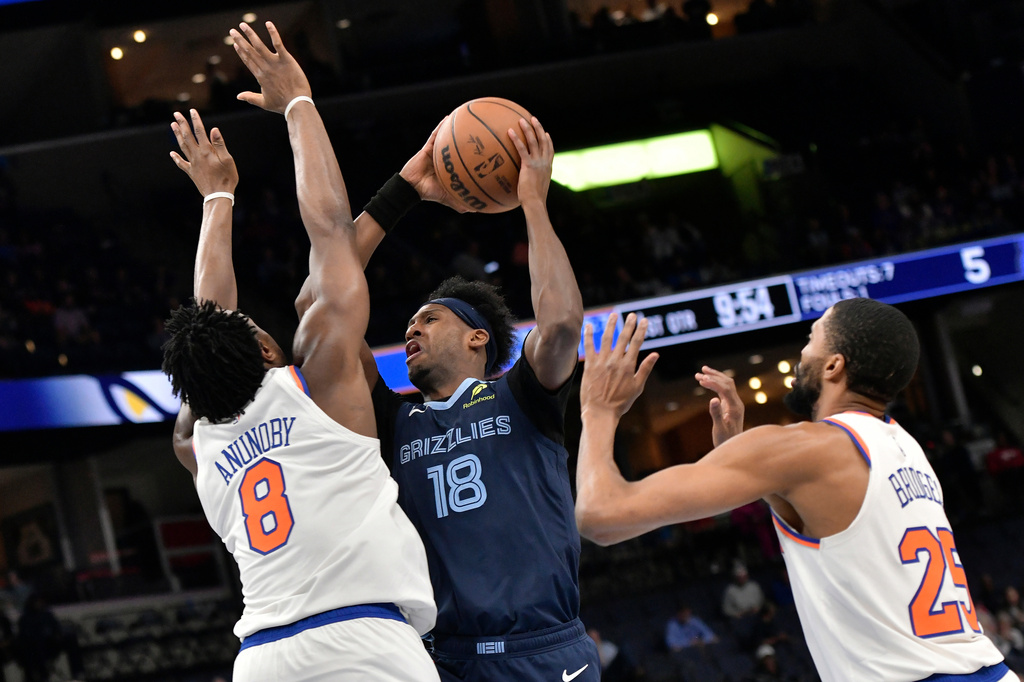 Memphis Grizzlies forward Olivier-Maxence Prosper (18) shoots against New York Knicks forward OG Anunoby (8) and guard Mikal Bridges (25) in the first half of an NBA basketball game Wednesday, April 1, 2026, in Memphis, Tenn. (AP Photo/Brandon Dill)