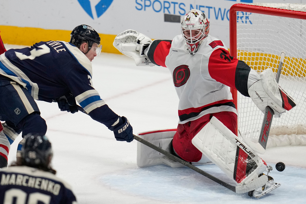 Columbus Blue Jackets' Charlie Coyle (3) scores on Carolina Hurricanes goalie Brandon Bussi, right, in the first period of an NHL hockey game in Columbus, Tuesday, March 17, 2026. (AP Photo/Sue Ogrocki)