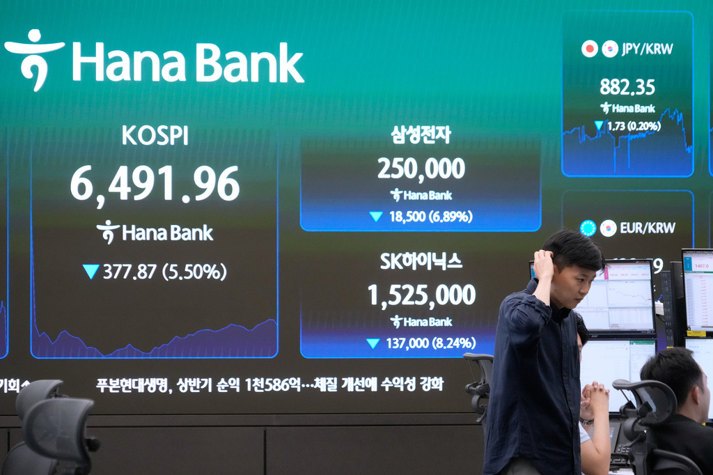 Currency traders work near a screen showing the Korea Composite Stock Price Index (KOSPI), SK Hynix and Samsung Electronics Co. stock price at the foreign exchange dealing room of the Hana Bank headquarters in Seoul, South Korea, Wednesday, Aug. 19, 2026. (AP Photo/Ahn Young-joon)