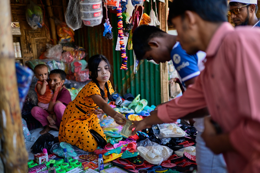 A Rohingya refugee girl sells goods at her stall inside a Rohingya refugee camp in Cox's Bazar, Bangladesh, Friday, Nov. 21, 2025. (AP Photo/Mahmud Hossain Opu)