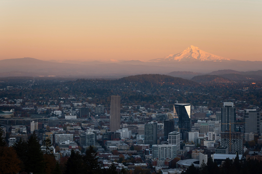 FILE - With Mount Hood in the background, the sun sets over downtown Portland, Ore., on Wednesday, Nov. 6, 2024. (AP Photo/Jenny Kane, File)