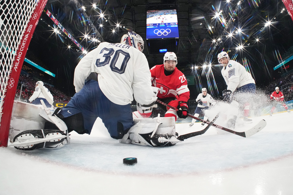 Switzerland's Timo Meier, center, scores his sides third goal past France's goalkeeper Antoine Keller during a preliminary round match of men's ice hockey between Switzerland and France at the 2026 Winter Olympics, in Milan, Italy, Thursday, Feb. 12, 2026. (Mike Segar/Pool Photo via AP)