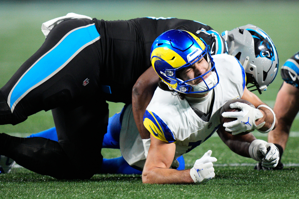 Los Angeles Rams wide receiver Puka Nacua, bottom, is tackled by Carolina Panthers defensive end Derrick Brown during the second half of an NFL wild-card playoff football game, Saturday, Jan. 10, 2026, in Charlotte, N.C. (AP Photo/Jacob Kupferman)