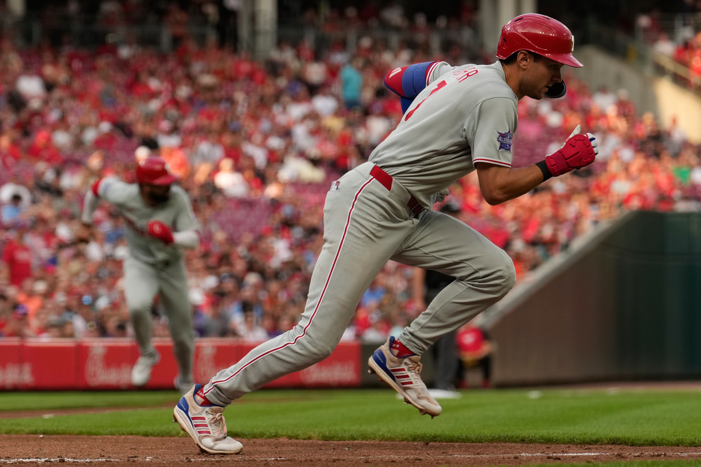 Philadelphia Phillies' Trea Turner grounds out as he runs to first base as Derek Hill scores, at left, and during the third inning of a baseball game against the Cincinnati Reds in Cincinnati, Tuesday, July 7, 2026. (AP Photo/Carolyn Kaster)