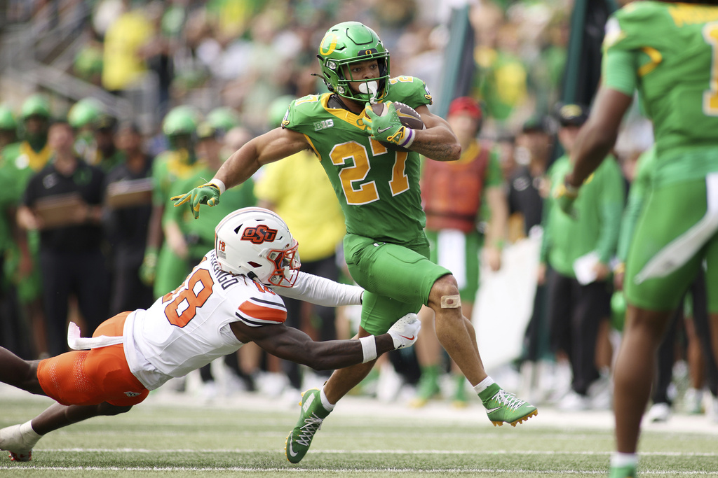Oregon running back Jayden Limar (27) attempts to break a tackle by Oklahoma State safety David Kabongo (18) during the second half of an NCAA college football game, Saturday, Sept. 6, 2025, in Eugene, Ore. (AP Photo/Lydia Ely)