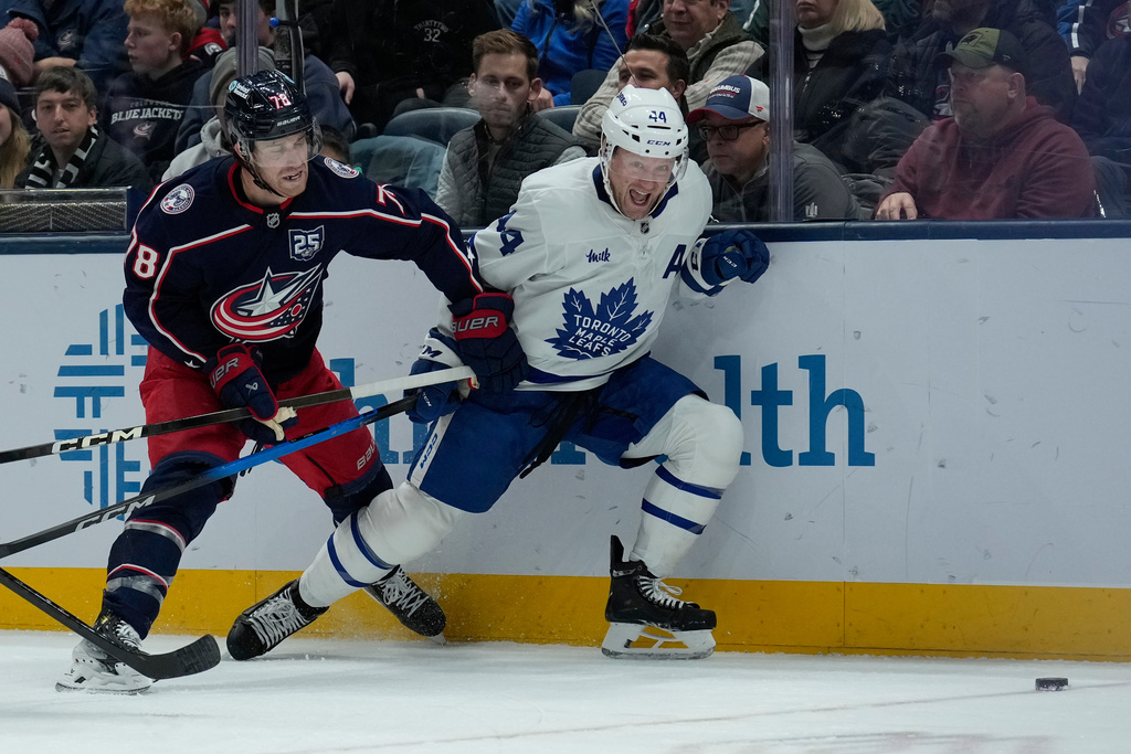 Columbus Blue Jackets defenseman Damon Severson (78) and Toronto Maple Leafs defenseman Morgan Rielly (44) battle for the puck in the second period of an NHL hockey game, Wednesday, Nov. 26, 2025, in Columbus, Ohio. (AP Photo/Carolyn Kaster)