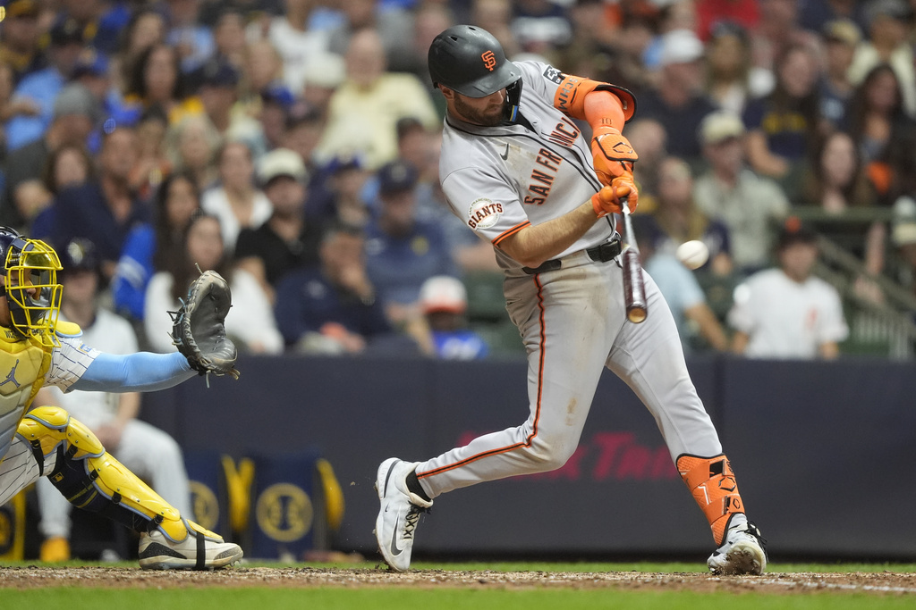 San Francisco Giants' Casey Schmitt hits a three-run home run during the seventh inning of a baseball game against the Milwaukee Brewers, Saturday, Aug. 23, 2025, in Milwaukee. (AP Photo/Aaron Gash)