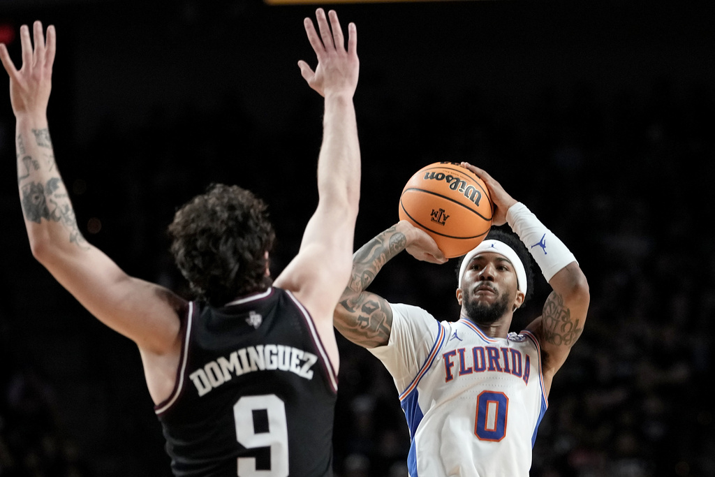 Florida guard Boogie Fland (0) shoots a 3-point shot against Texas A&M guard Rubén Dominguez (9) during the first half of an NCAA college basketball game Saturday, Feb. 7, 2026, in College Station, Texas. (AP Photo/Sam Craft)