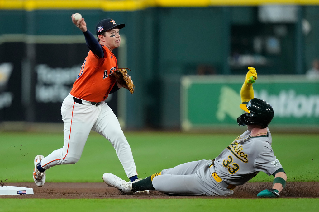 Houston Astros shortstop Nick Allen, left, turns a double play after forcing out Athletics' Henry Bolte (33) during the first inning of a baseball game Friday, Aug. 21, 2026, in Houston. (AP Photo/Kevin M. Cox)