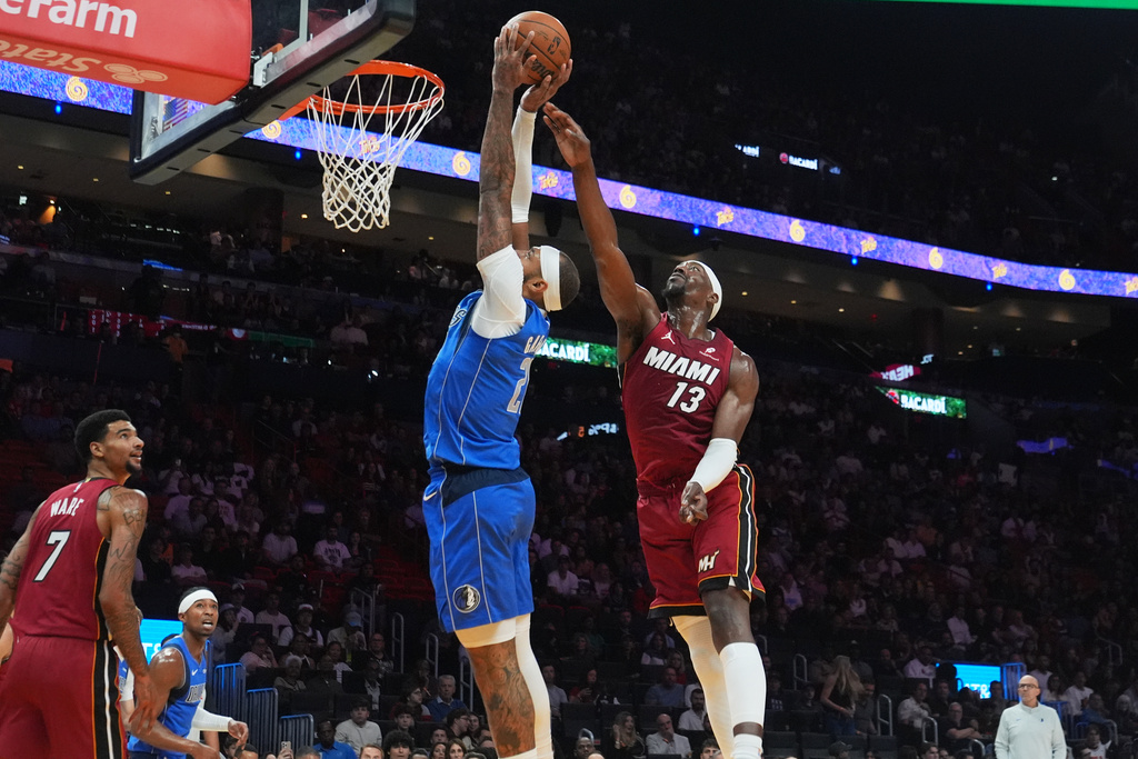 Dallas Mavericks forward Daniel Gafford (21) aims to score as Miami Heat center Bam Adebayo (13) defends during the first half of an NBA basketball game Monday Nov. 24, 2025, in Miami. (AP Photo/Marta Lavandier)