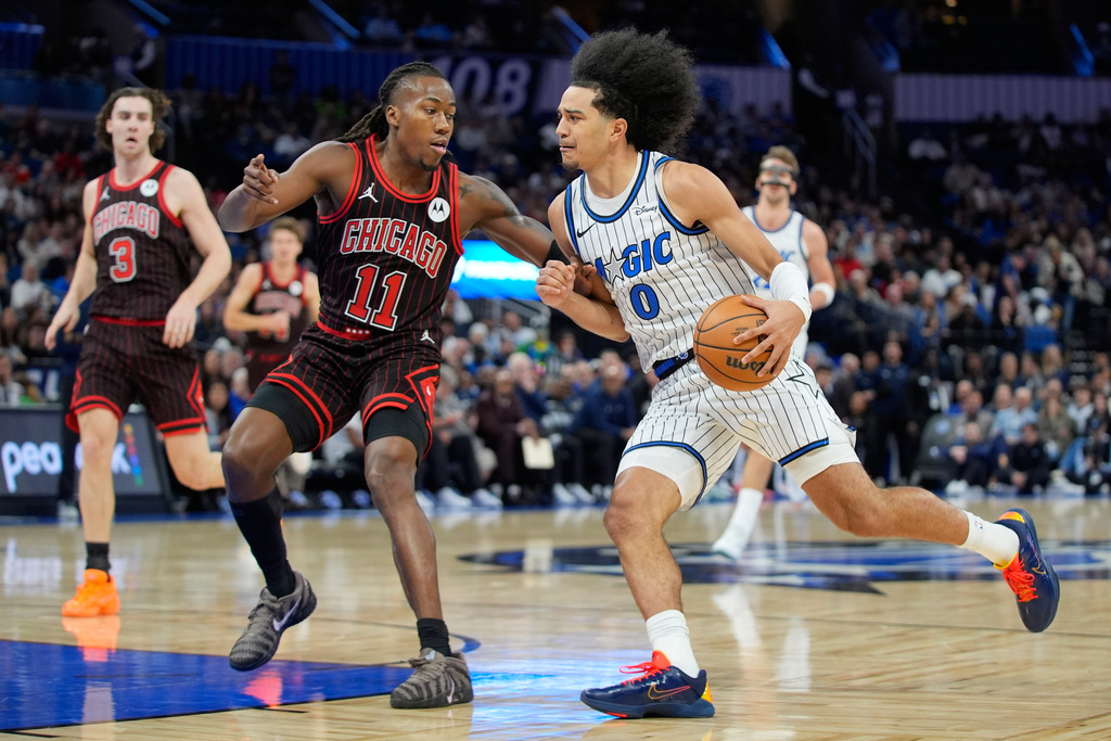 Orlando Magic guard Anthony Black (0) drives past Chicago Bulls guard Ayo Dosunmu (11) during the first half of an NBA basketball game, Monday, Dec. 1, 2025, in Orlando, Fla. (AP Photo/John Raoux)