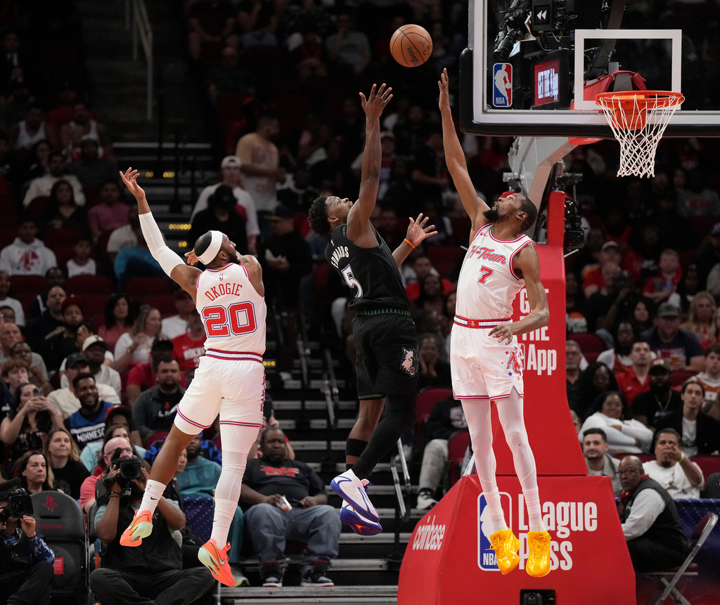 Houston Rockets' Kevin Durant (7) and Josh Okogie (20) defend against Minnesota Timberwolves guard Anthony Edwards (5) during the first half of an NBA basketball game, Friday, April 10, 2026, in Houston. (AP Photo/ Karen Warren)