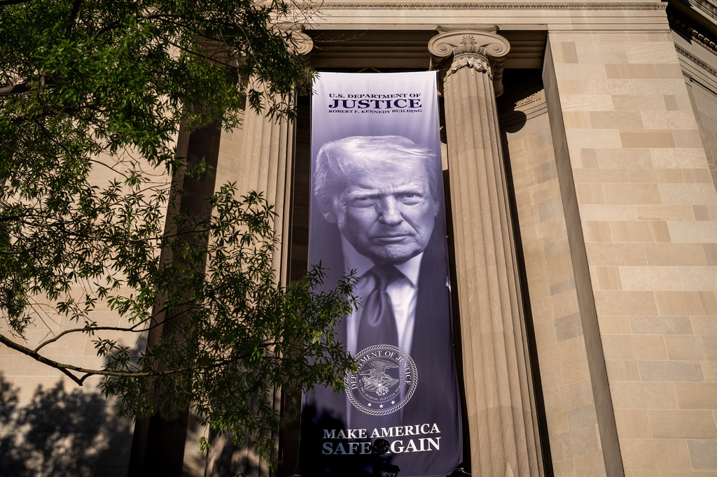 A giant portrait of President Donald Trump looks down from the Justice Department in Washington, Tuesday, June 2, 2026. The Justice Department said it would comply with a court order pausing the implementation of a $1.776 billion settlement fund designed to compensate President Donald Trump's political allies after GOP senators revolted. (AP Photo/J. Scott Applewhite)