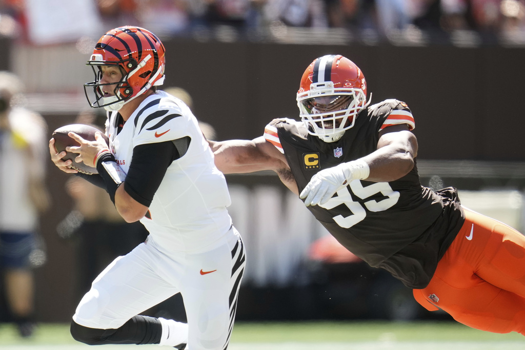 Cincinnati Bengals quarterback Joe Burrow, left, is tackled by Cleveland Browns defensive end Myles Garrett (95) during the first half of an NFL football game Sunday, Sept. 7, 2025, in Cleveland. (AP Photo/Sue Ogrocki)