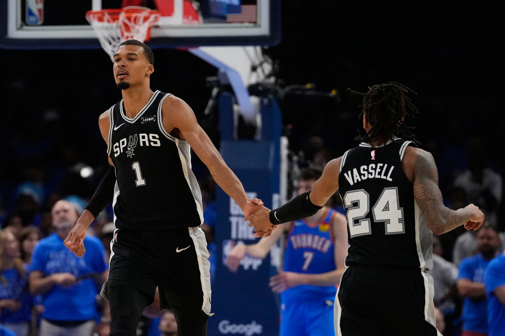 San Antonio Spurs forward Victor Wembanyama (1) celebrates with guard Devin Vassell (24) during the second overtime of Game 1 in a third-round NBA basketball playoffs series against the Oklahoma City Thunder Monday, May 18, 2026, in Oklahoma City. (AP Photo/Tony Gutierrez)