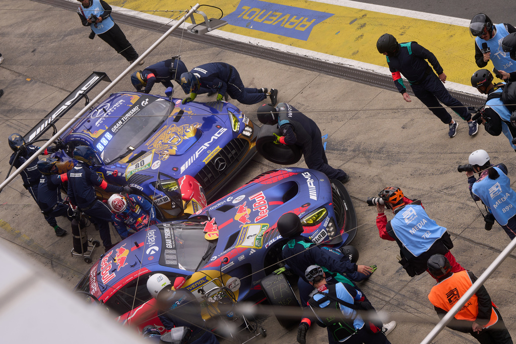 The pit crew works on the leading Max Verstappen's Mercedes AMG GT3 car, right, as it completes a pit stop at the same time as the second-placed Mercedes-AMG Team RAVENOL with Germany's Maro Engel, Germany's Luca Stolz, Germany's Fabian Schiller and Germany's Maxime Martin, during the Nurburgring 24-hour auto race in Nurburg, Germany, Sunday, May 17, 2026. (Thomas Frey/dpa via AP)
