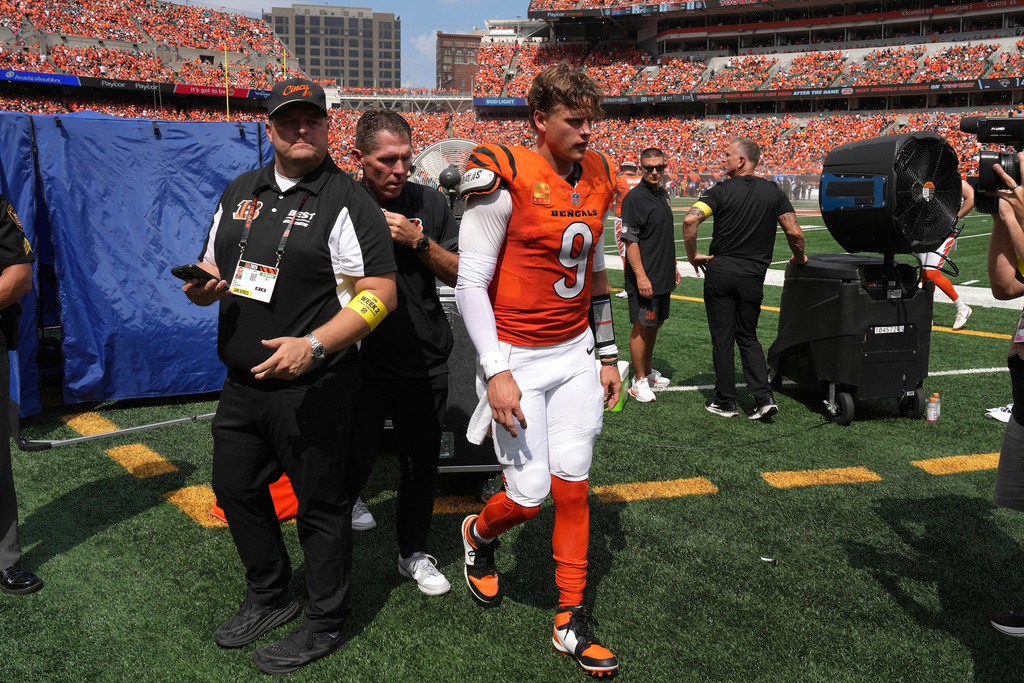 FILE - Cincinnati Bengals quarterback Joe Burrow, center, is exits the medical tent for the locker room after suffering an injury during the second quarter of an NFL football game against the Jacksonville Jaguars, Sept. 14, 2025, in Cincinnati. (AP Photo/Kareem Elgazzar, File)