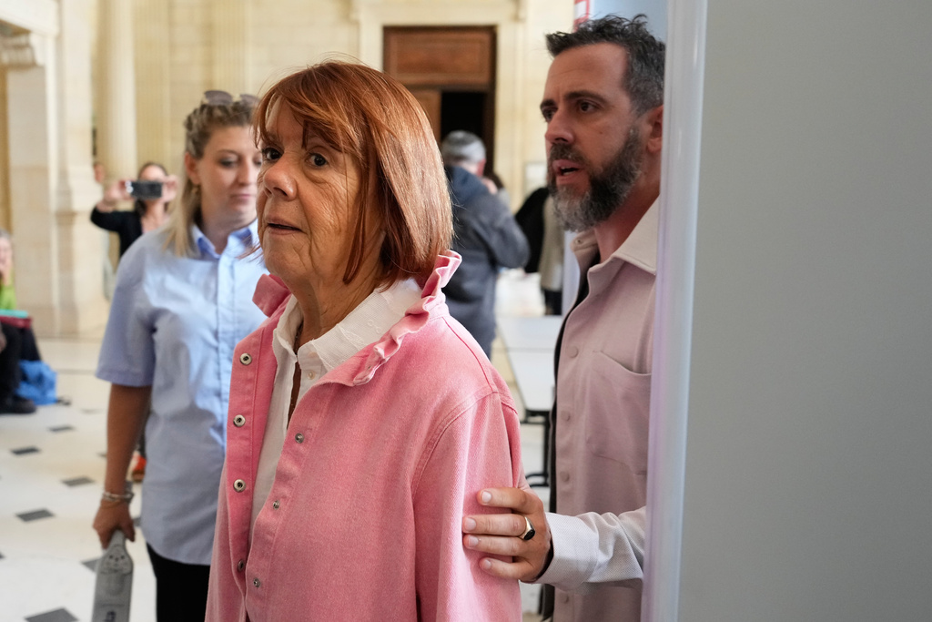 Gisele Pelicot followed by her son Florian Pelicot leave the courtroom during the appeals trial in the case of a man challenging his conviction, less than a year after the landmark verdict in a drugging and rape trial that shook France Thursday, Oct. 9, 2025 in Nimes, southern France. (AP Photo/Lewis Joly)