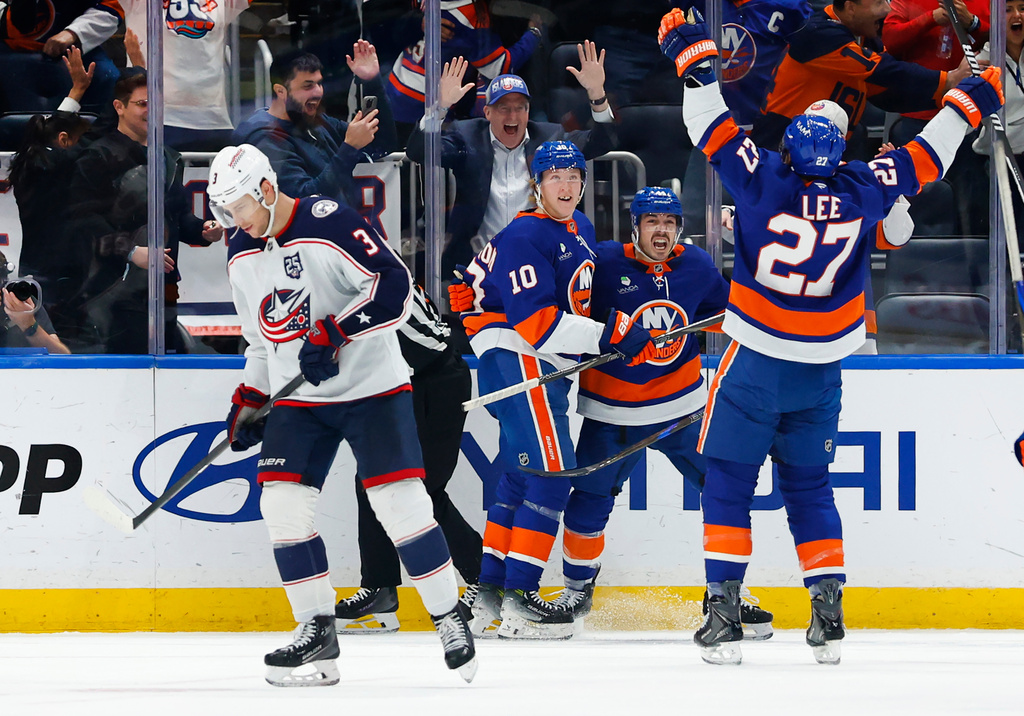 Columbus Blue Jackets center Charlie Coyle (3) skates to the bench as New York Islanders Anders Lee (27) and Jean-Gabriel Pageau, celebrate after a goal by Simon Holmstrom (10) during the third period of an NHL hockey game against the Columbus Blue Jackets, Sunday, Nov. 2, 2025, in New York. (AP Photo/Noah K. Murray)