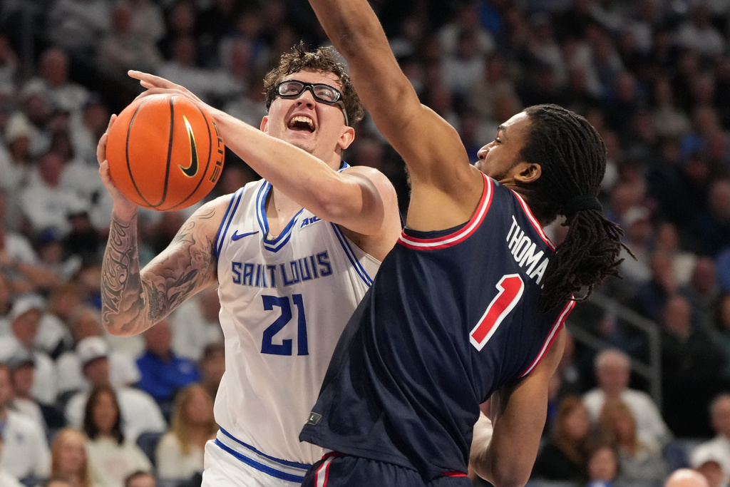 Saint Louis' Robbie Avila (21) heads to the basket as Dayton's Malcolm Thomas (1) defends during the second half of an NCAA college basketball game Friday, Jan. 30, 2026, in St. Louis. (AP Photo/Jeff Roberson)
