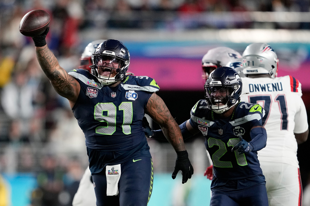 FILE - Seattle Seahawks defensive tackle Byron Murphy II (91) celebrates with cornerback Devon Witherspoon (21) after recovering a fumble by New England Patriots quarterback Drake Maye during the second half of the NFL Super Bowl 60 football game, Feb. 8, 2026, in Santa Clara, Calif. (AP Photo/Doug Benc, File)