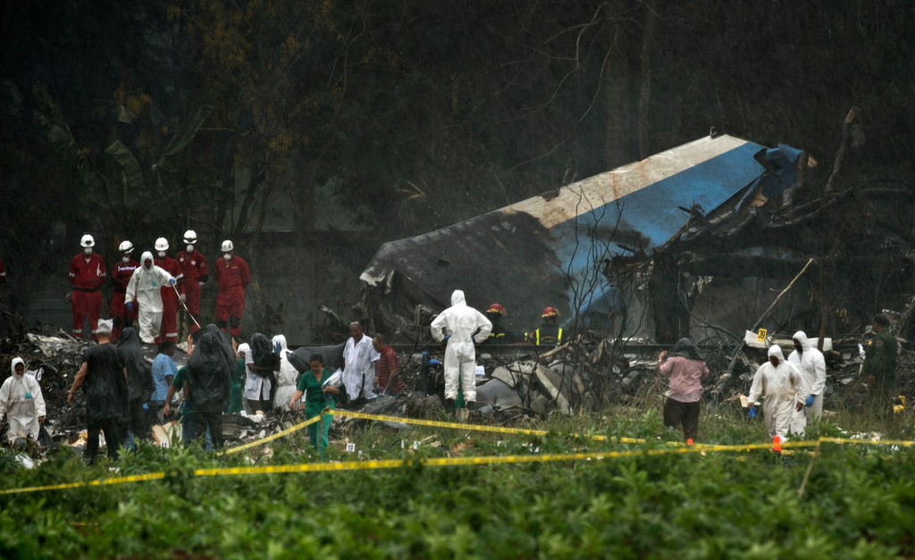 FILE - Rescue teams search through the wreckage site of a Boeing 737 that plummeted into a cassava field with more than 100 passengers on board, in Havana, Cuba, May 18, 2018 . (AP Photo/Ramon Espinosa, File)