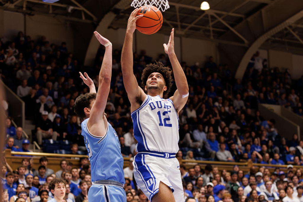 Duke's Cameron Boozer (12) attempts to shoot against Indiana State's Ian Scott, left, during the second half of an NCAA college basketball game in Durham, N.C., Friday, Nov. 14, 2025. (AP Photo/Ben McKeown)