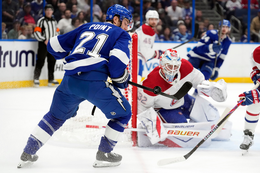 Tampa Bay Lightning center Brayden Point (21) plays the puck in front of Montréal Canadiens goaltender Jacob Fowler (32) during the second period of an NHL hockey game Sunday, Dec. 28, 2025, in Tampa, Fla. (AP Photo/Chris O'Meara)