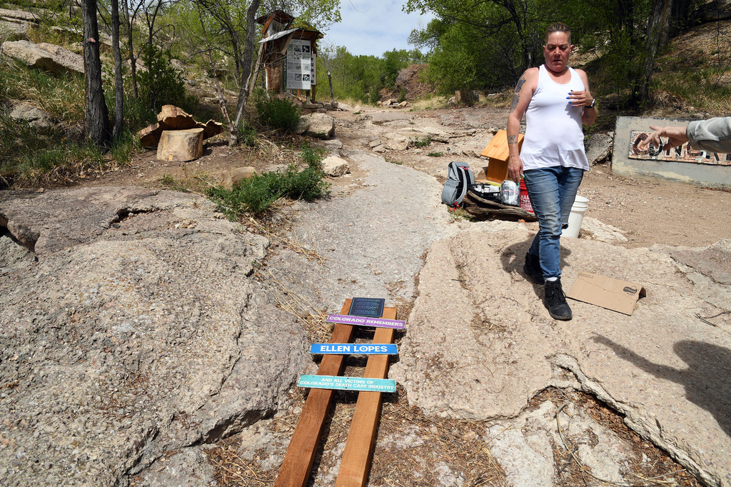 Crystina Page, whose son's body was among nearly 200 found decomposing in a southern Colorado funeral home in 2023, looks at a set of memorial signs for the victims in Colorado Springs, Colo., on Wednesday, April 22, 2026. (AP Photo/Thomas Peipert)